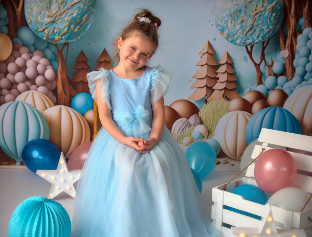 sesja przedszkolna, dziewczynka w niebieskiej sukience na tle balonów